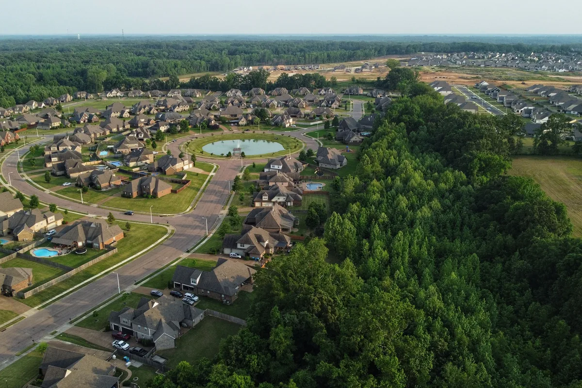 Aerial view of single-family houses next to woods